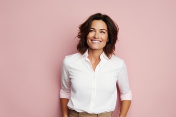 Portrait of a joyful woman in her 40s wearing a simple cotton shirt against a pastel pink background. AI Generation