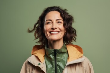 Obraz premium Portrait of a satisfied woman in her 40s dressed in a water-resistant gilet against a pastel green background. AI Generation