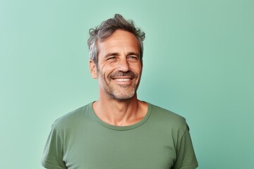 Obraz premium Portrait of a glad man in his 40s dressed in a casual t-shirt against a pastel green background. AI Generation
