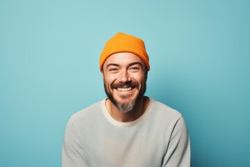 Portrait of a cheerful man in his 30s sporting a trendy beanie against a pastel orange background. AI Generation