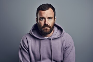 Obraz premium Portrait of a glad man in his 30s sporting a comfortable hoodie against a pastel gray background. AI Generation