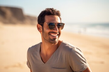 Portrait of a grinning man in his 30s wearing a trendy sunglasses against a sandy beach background. AI Generation