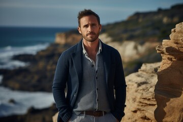Portrait of a satisfied man in his 30s wearing a chic cardigan against a rocky cliff background. AI...