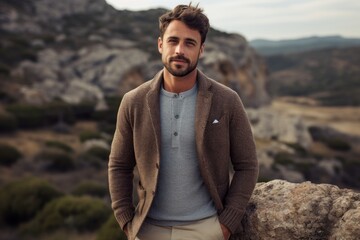 Portrait of a satisfied man in his 30s wearing a chic cardigan against a rocky cliff background. AI...