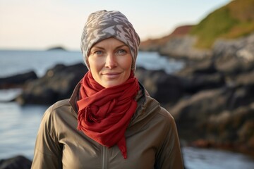 Portrait of a glad woman in her 40s wearing a protective neck gaiter against a peaceful tide pool background. AI Generation - obrazy, fototapety, plakaty