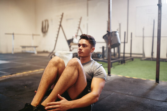 Fit young man exercising on the floor of a gym
