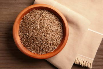 rice in a bowl, Bowl of caraway seeds and napkin on wooden table, top view - obrazy, fototapety, plakaty