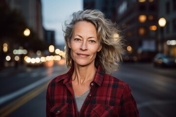 Fototapeta premium Portrait of a tender woman in her 50s wearing a comfy flannel shirt against a bustling city street background. AI Generation