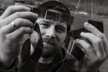 Man looks with interest at a vintage photographic film. Concept of genealogy, the memory of...