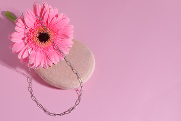 Silver jewelry chain on stone and natural flower, elegant gift