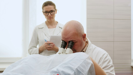 Obraz premium A gynecologist and a nurse consult a patient and conduct a gynecological examination in preparation for pregnancy. Pregnancy and childbirth consultations, women's health and teamwork.