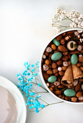 Fototapeta premium On a light background there is a round box filled with various nuts and dried fruits. Mothers Day. Valentine's Day. International Women's Day.A delightful gift. Low-fat food.