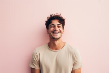Portrait of a smiling man in his 30s donning a trendy cropped top against a pastel or soft colors...