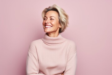 Portrait of a joyful woman in her 40s dressed in a warm wool sweater against a pastel or soft...