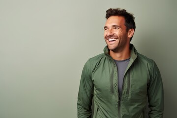 Fototapeta premium Portrait of a smiling man in his 30s sporting a breathable hiking shirt against a minimalist or empty room background. AI Generation