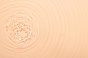 Water beige surface abstract background. Waves and ripples texture of cosmetic aqua moisturizer with bubbles.