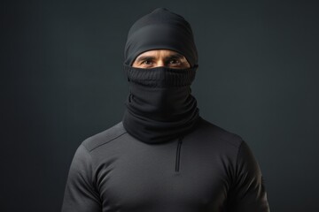 Portrait of a glad man in his 30s wearing a protective neck gaiter against a minimalist or empty room background. AI Generation