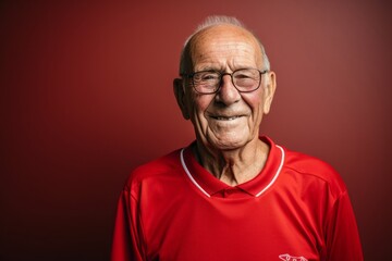 Obraz premium Portrait of a jovial man in his 80s sporting a breathable mesh jersey against a minimalist or empty room background. AI Generation