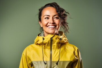 Portrait of a glad woman in her 40s sporting a waterproof rain jacket against a solid color backdrop. AI Generation