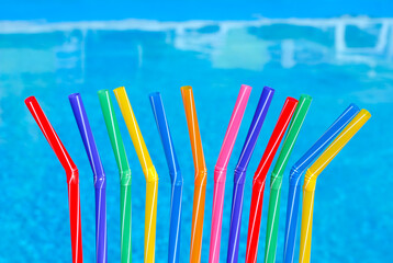 Cocktail straws against the background of a blue pool.