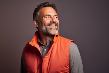 Fototapeta premium Portrait of a satisfied man in his 40s dressed in a water-resistant gilet against a solid color backdrop. AI Generation