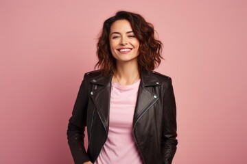 Portrait of a grinning woman in her 30s sporting a stylish leather blazer against a solid pastel...