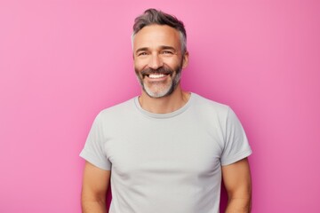 Obraz premium Portrait of a happy man in his 40s sporting a vintage band t-shirt against a solid pastel color wall. AI Generation