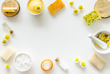 White and yellow chamomile flowers with herbal cosmetic beauty products