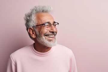 Portrait of a joyful man in his 70s sporting a long-sleeved thermal undershirt against a solid...