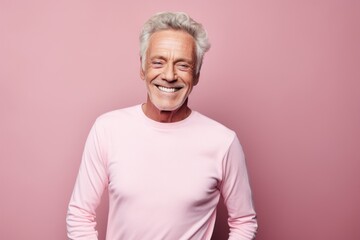 Portrait of a joyful man in his 70s sporting a long-sleeved thermal undershirt against a solid pastel color wall. AI Generation