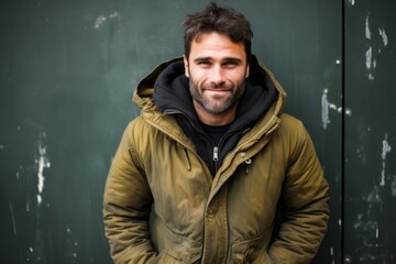 Portrait of a glad man in his 30s wearing a warm parka against a bare concrete or plaster wall. AI Generation