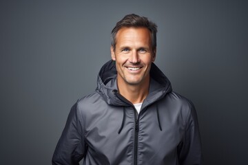 Obraz premium Portrait of a happy man in his 40s wearing a zip-up fleece hoodie against a light wood minimalistic setup. AI Generation