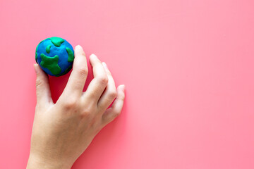 Plasticine globe planet Earth in hand - protection ecology concept