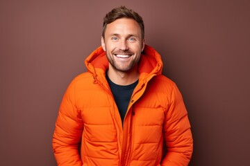 Fototapeta premium Portrait of a cheerful man in his 30s donning a durable down jacket against a crisp minimalistic living room. AI Generation