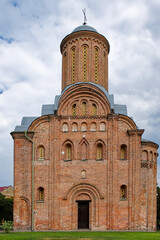 Fototapeta na wymiar The Pyatnitskaya Church, a red brick building crowned with a dome and a cross, standing against the backdrop of a clear and boundless sky, embodying the essence of a medieval brick church in Chernihiv