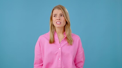 Blonde woman bites lip nervously and regulates breathing