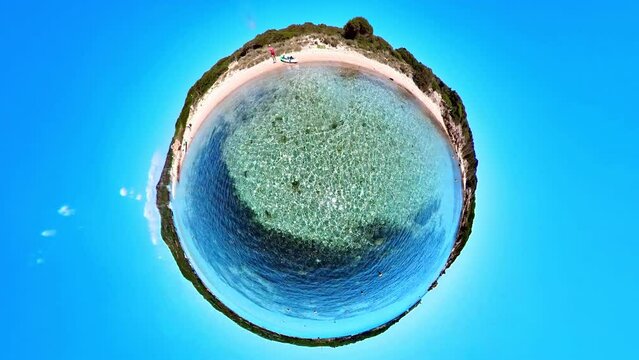 Tiny planet 360 view of the Mediterranean sea from Piantarella beach. Aerial view of the beach of Piana island in Corsica of France. Concept of environment with sea on cloudy sky background