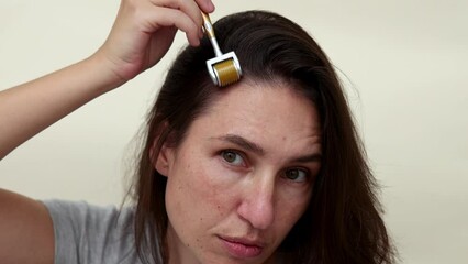 millennial woman using mezoroller with needles against hair loss,on scalp.girl with pills blisters in front of mouth. hair growth stimulation or treatment.crying over female head, on forehead.