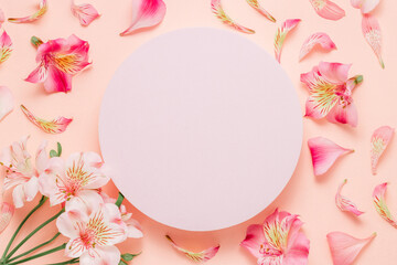 Empty podium with pink flowers and petals, top view. Background for cosmetic, perfume, design and product presentation.