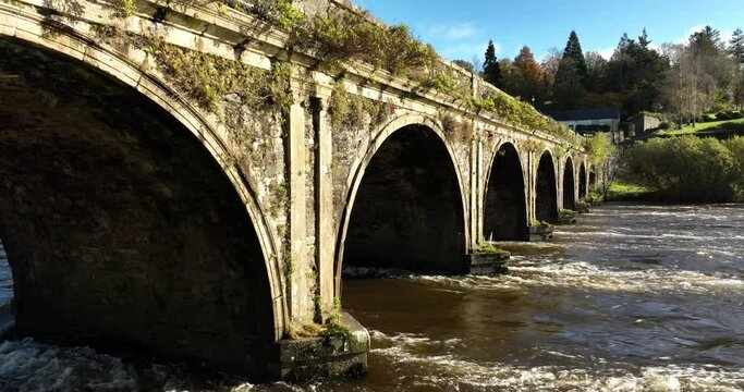 Historic old stone bridge over a strong river stream 4k