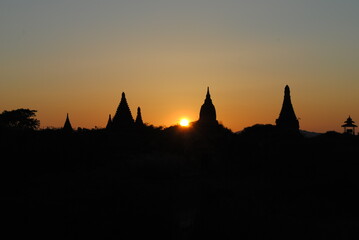 Silhouettes of Pagodas at Sunrise in Bagan, Myanmar. Peaceful view of pagoda silhouettes at sunrise in Bagan. The golden hues of the rising sun create a serene and spiritual atmosphere.