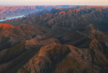 Fototapeta na wymiar Steppe mountains near the big Ili river in Kazakhstan, view from top at sunset
