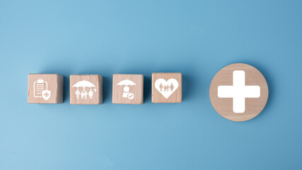 Concept of health insurance and medical. Wooden block with icons about health insurance and access to health care, health care planning on a blue background.