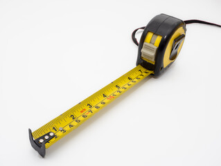 Close up of Dual scale measurements imperial and metric yellow and black tape measure isolated on a...