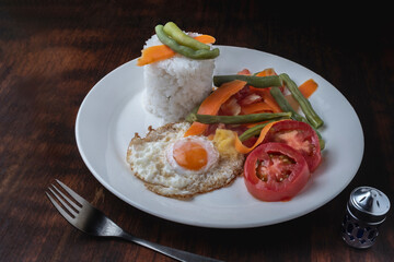 Fried rice with vegetables, rice chips, fried egg Indonesian cuisine