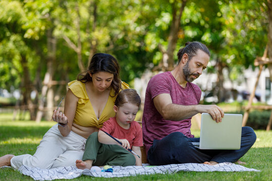 Happy family day, father, mother, son, Caucasian enjoying watercolor painting and picnic in nature.