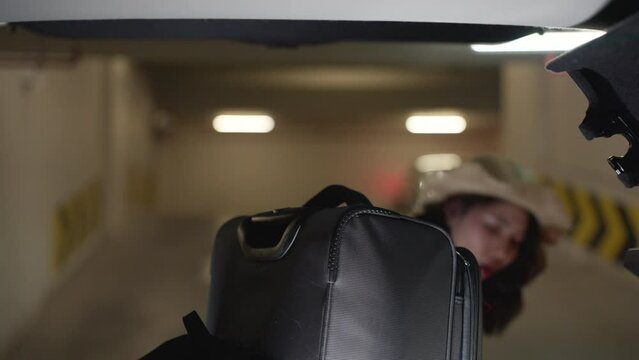 Asian woman opens the trunk of her car and is shocked by an accident when her bag falls.