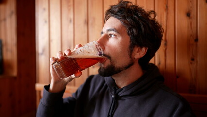 Savoring the Brew - Man Enjoying Draft Beer in Rustic Wooden Eatery