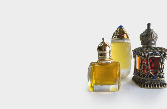 Traditional Arabian glass and decorated attar perfume bottles with gold fragrance, isolated on white copy space.