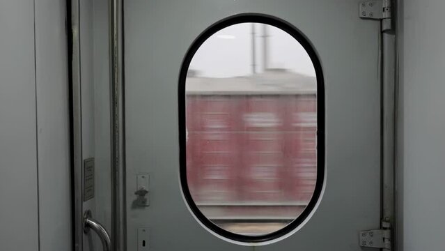 View from the vestibule of an old European train car on passing freight cars